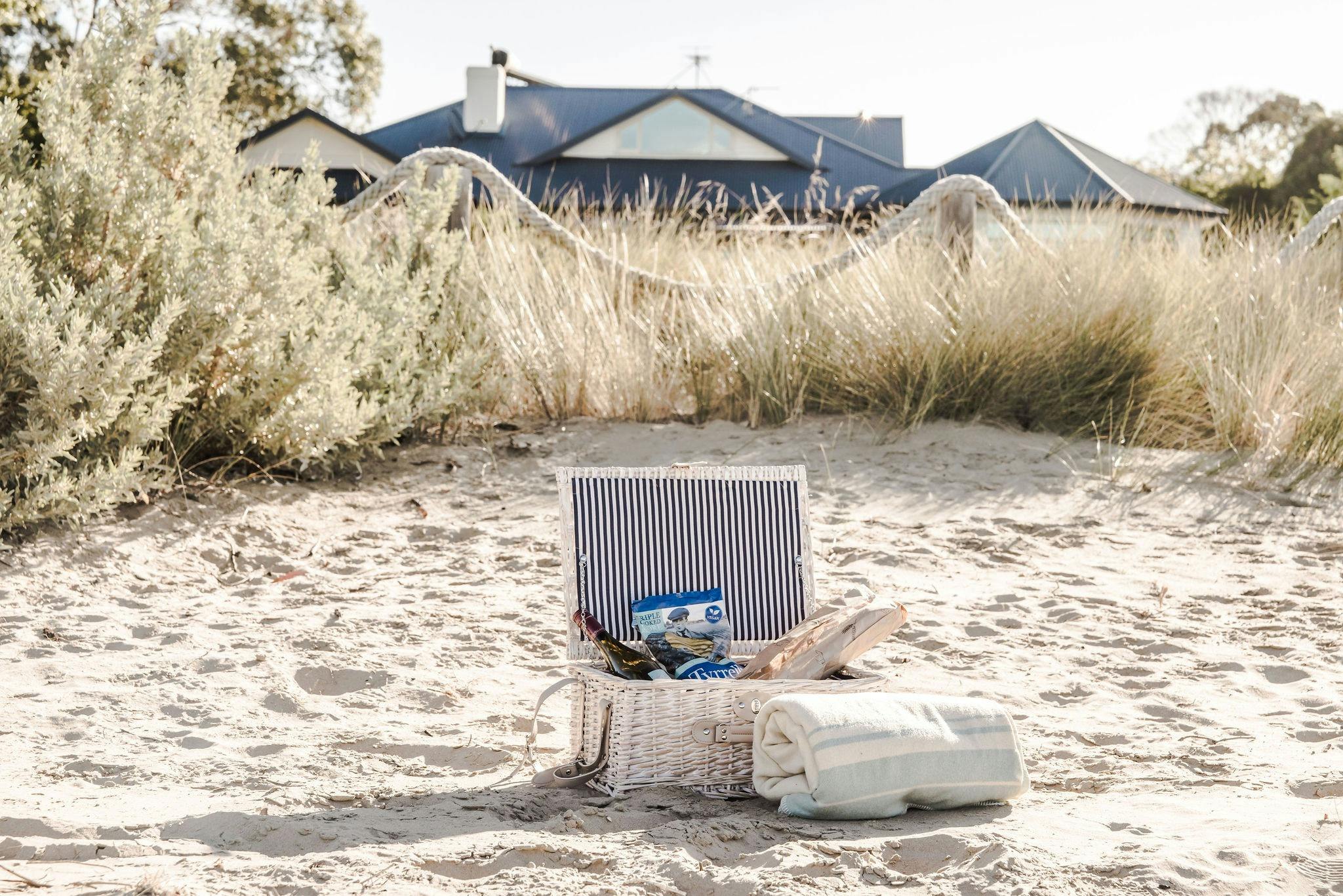 Picnic hamper on the sand on the beach directly in front of the house