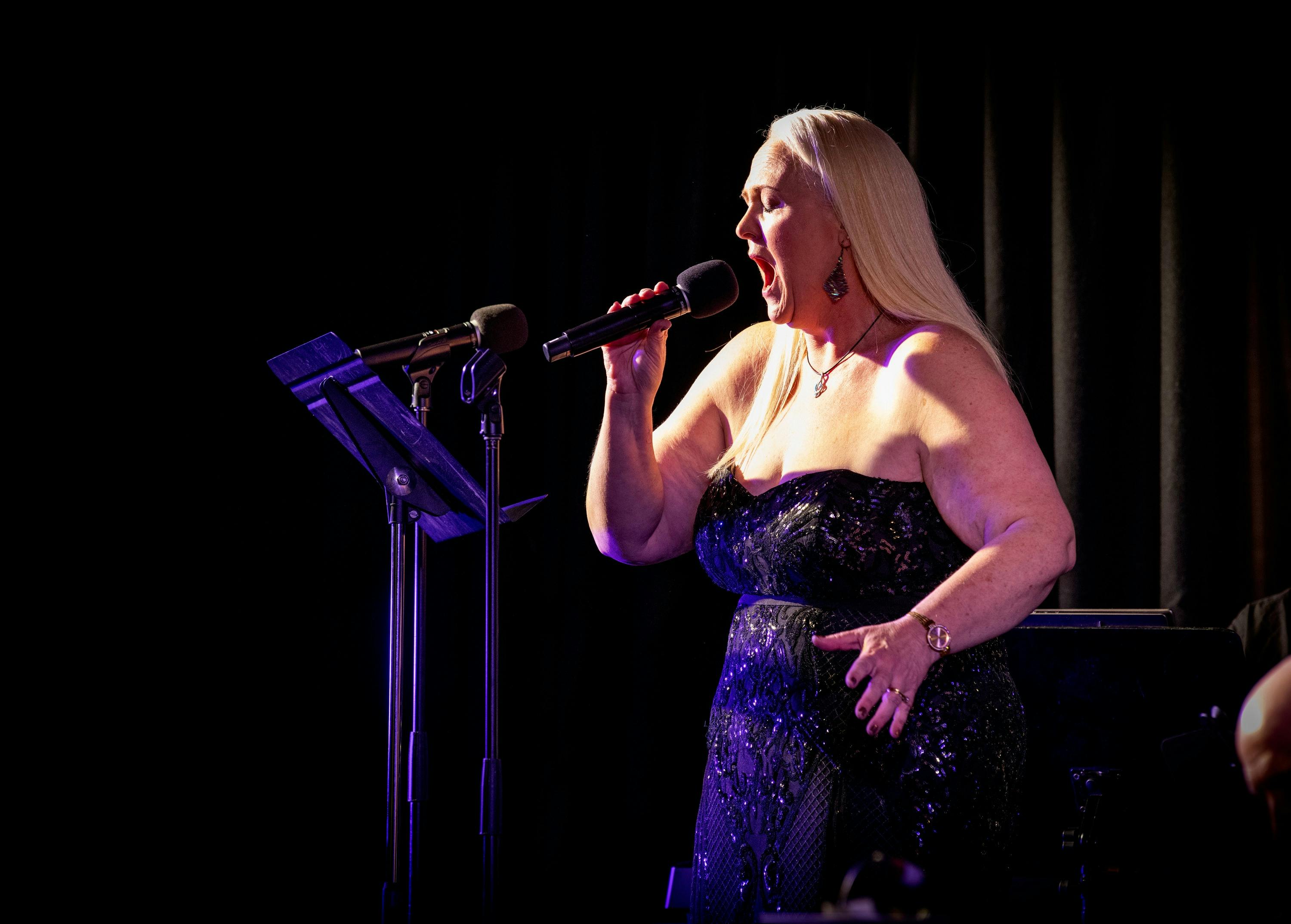 Female vocalist singing a big note.