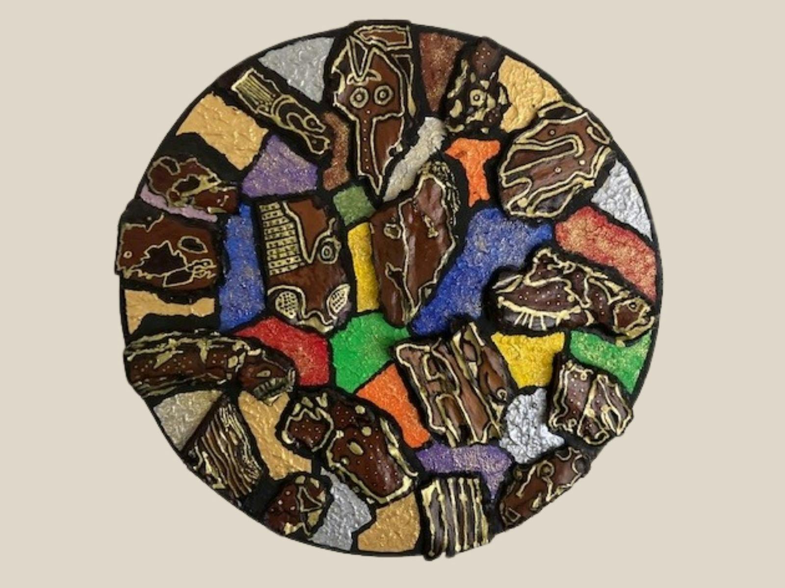 A circular mosaic artwork with abstract design featuring colourful segments and bark motifs