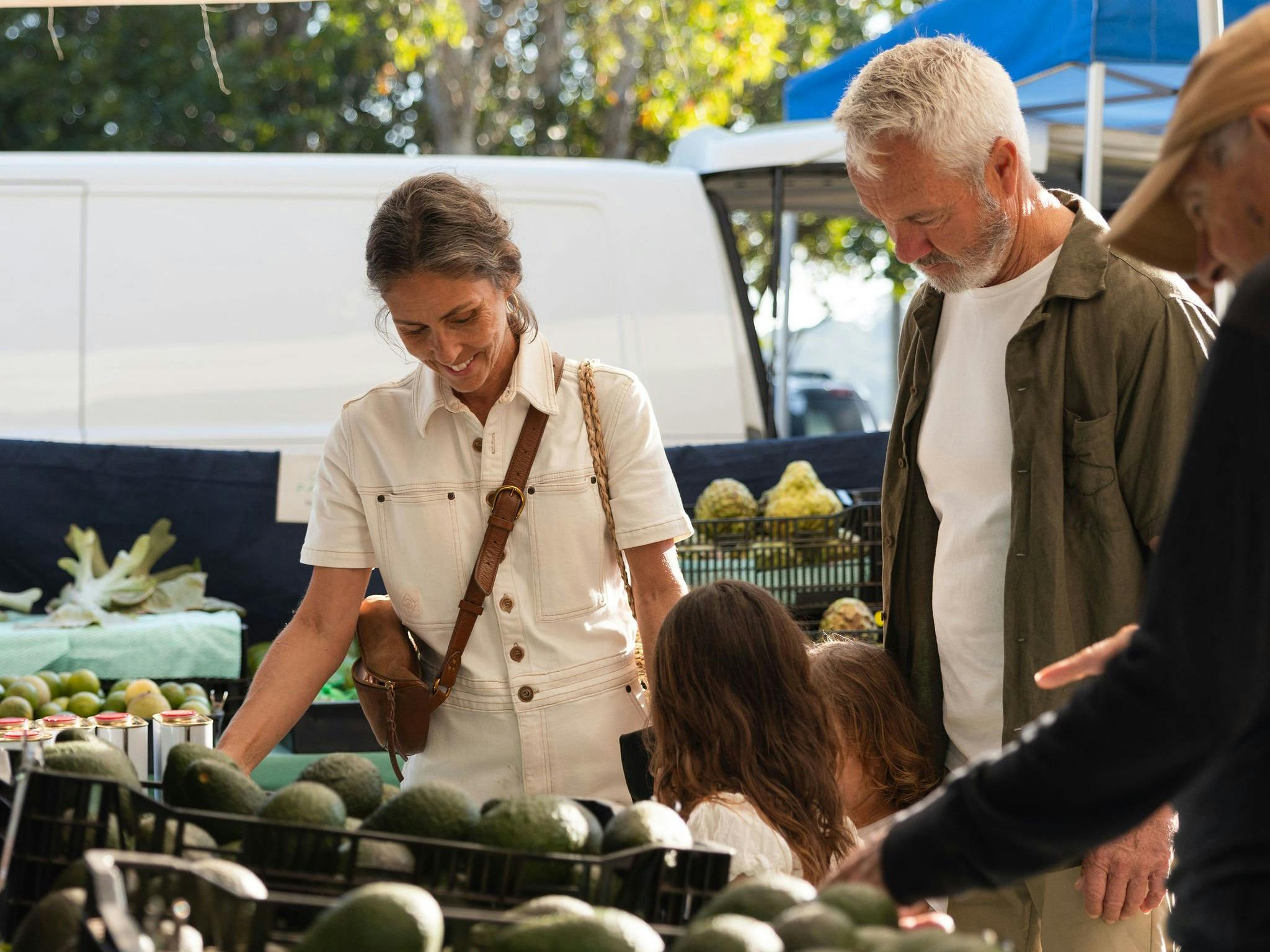 Image of a family purchasing avocadoes from a stall