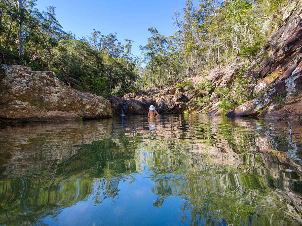Woman swimming in Rocky Hole and enjoying the scenery