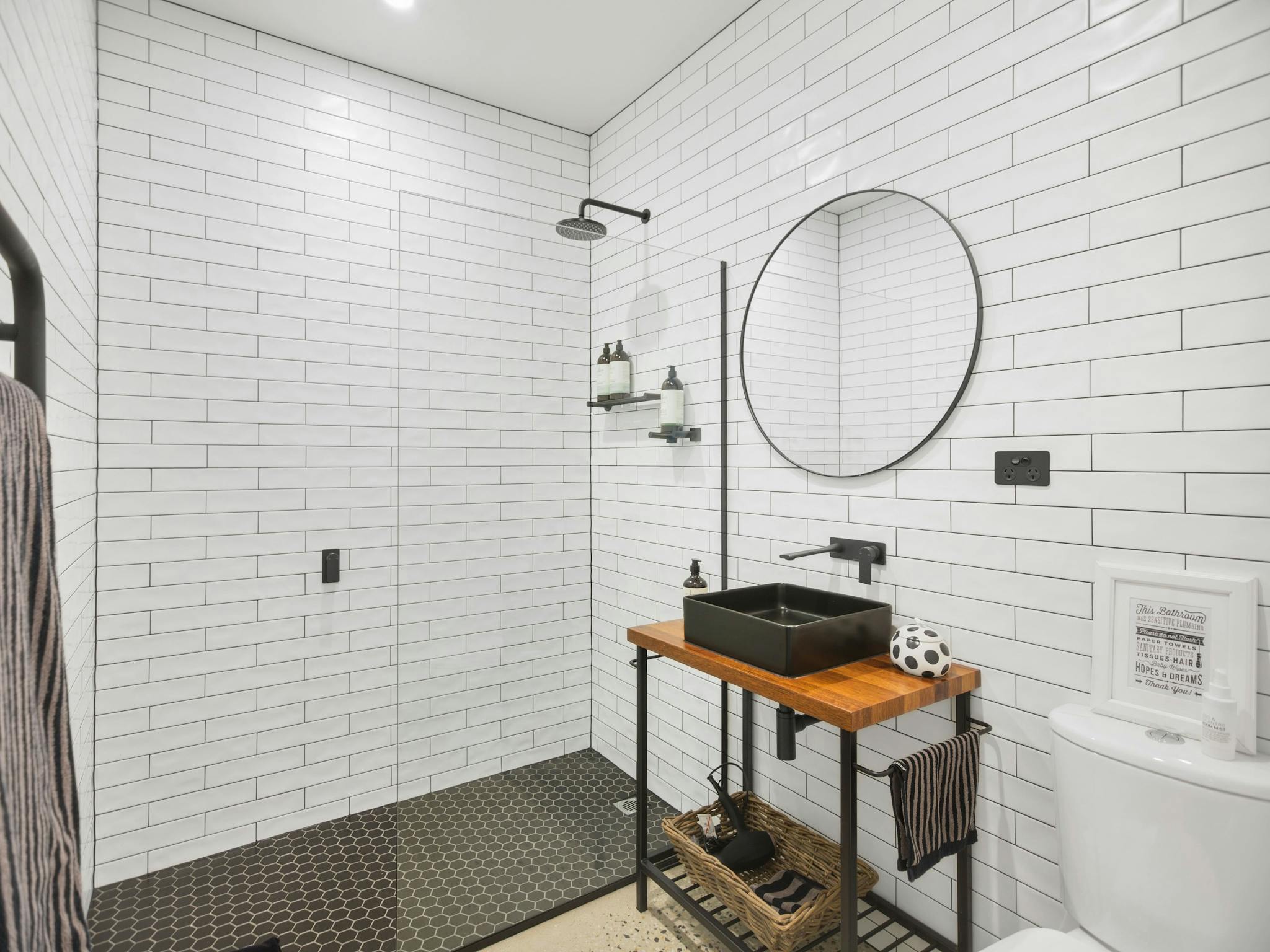 Typical En-suite Bathroom. Subway tiles, black grout, black and white theme, Marimekko towels.