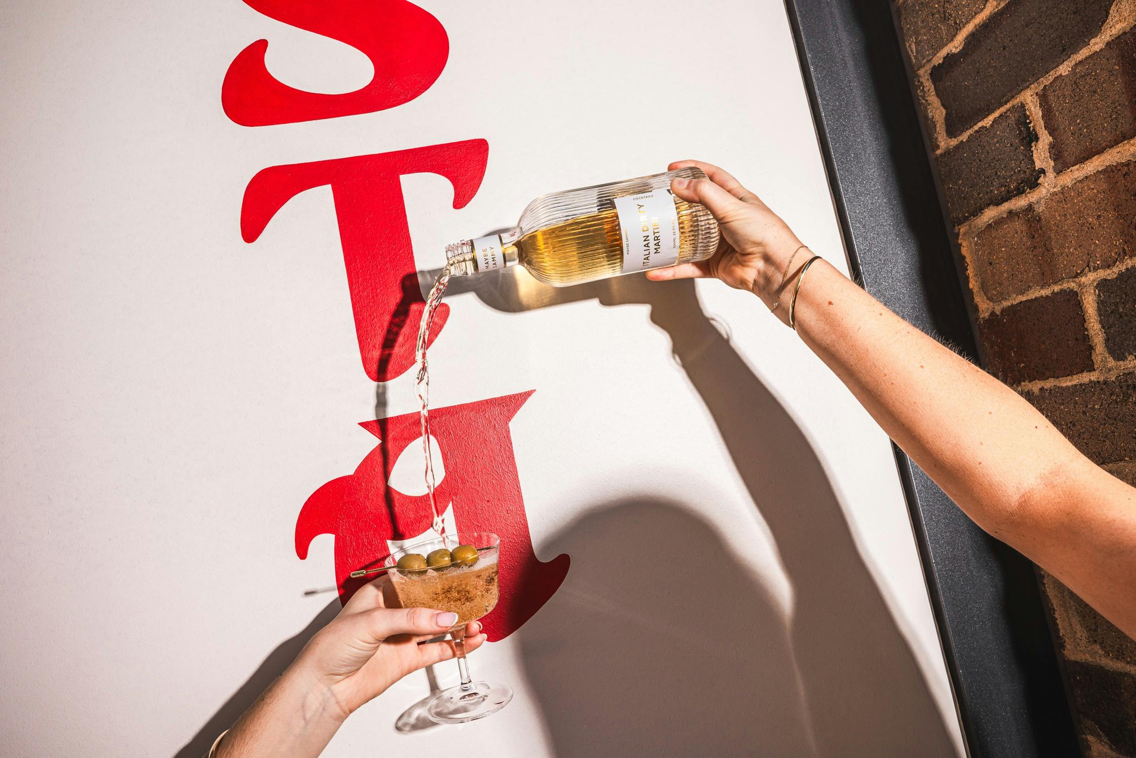 Drink being poured into martini glass