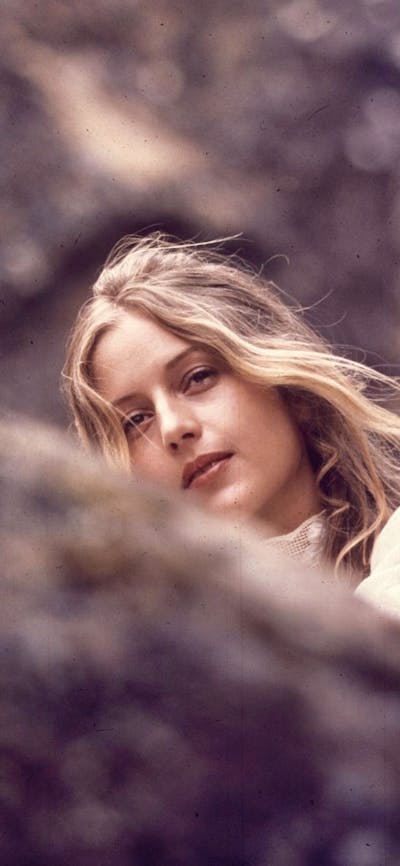 woman looking past camera, image from film of picnic at hanging rock