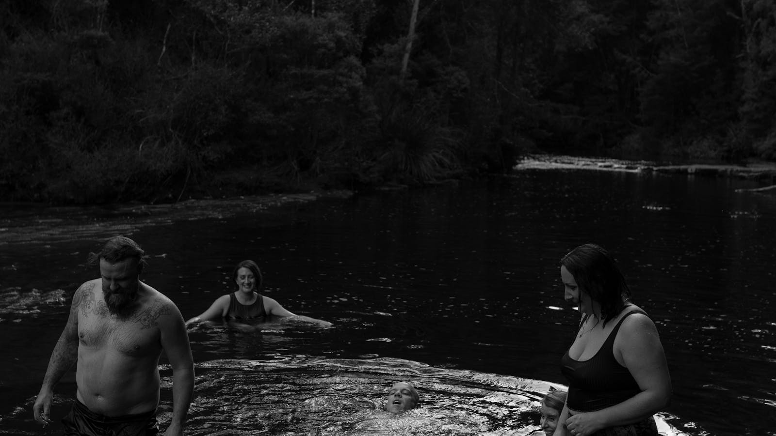 Guests cool off together in a Tasmanian river after a wood-fired sauna session.