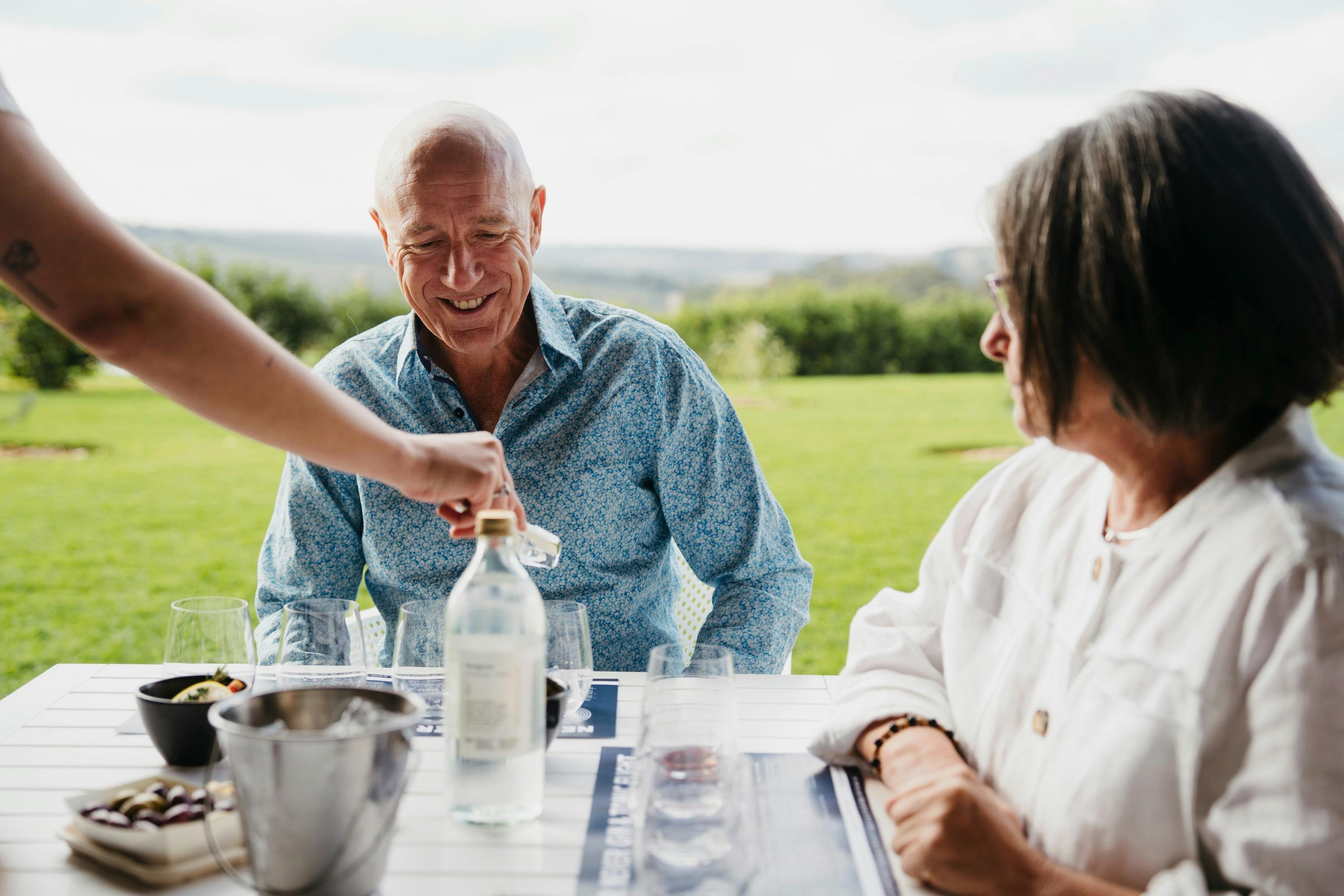 a man and a woman sitting at a table with a gin flight infront of them