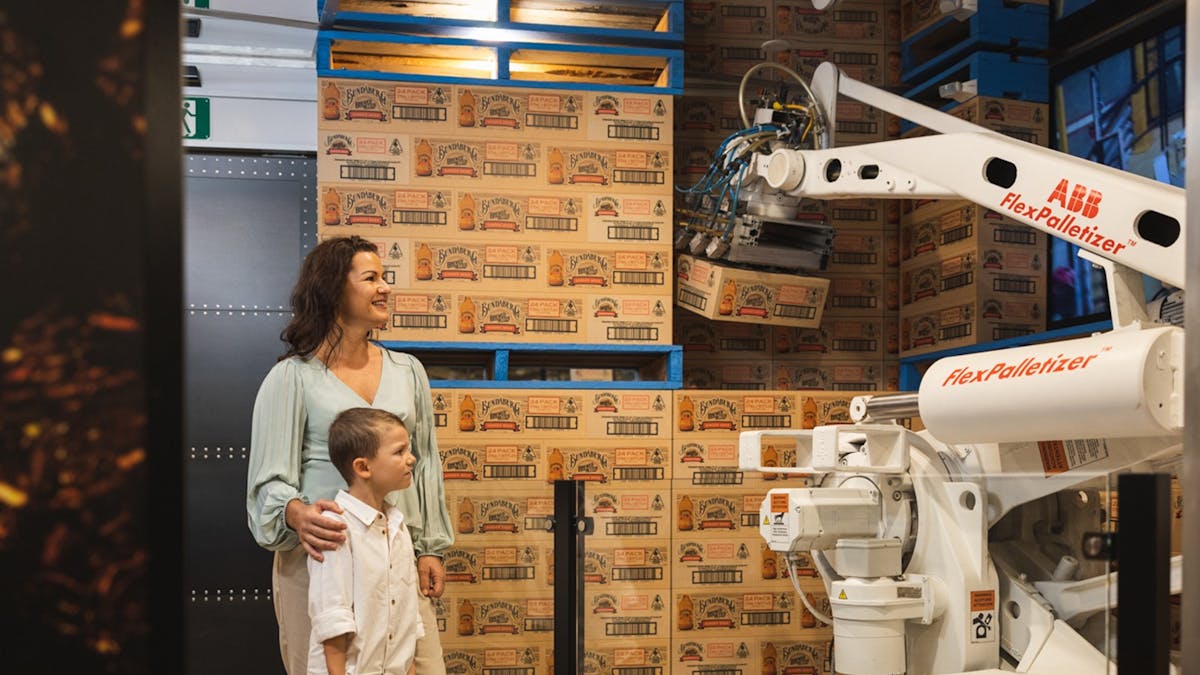 Family watching the packing process on a self-guided tour at Bundaberg Brewed Drinks Barrel.