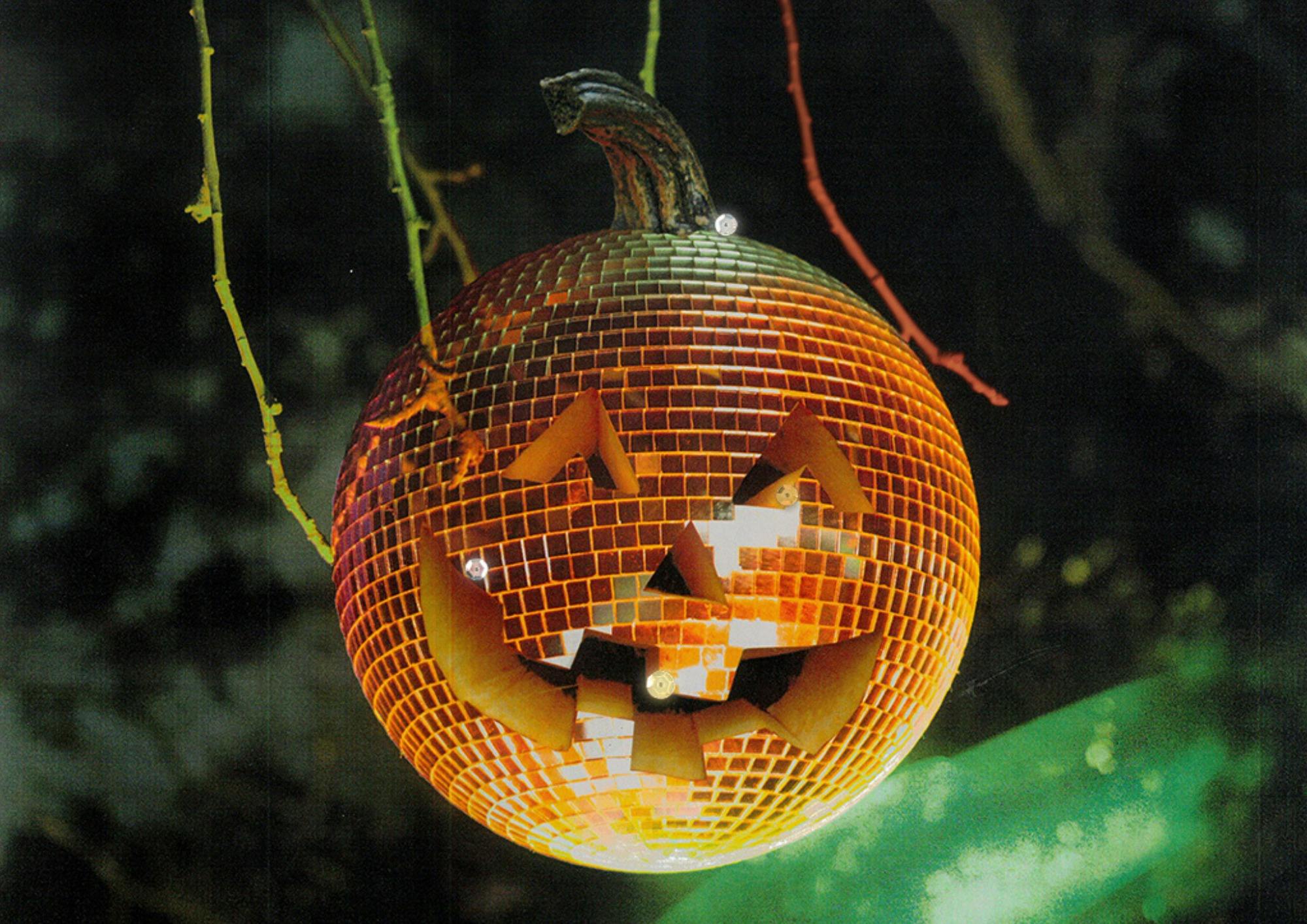A Jack o Lantin Mirror ball, orange and green, with a cut out grin