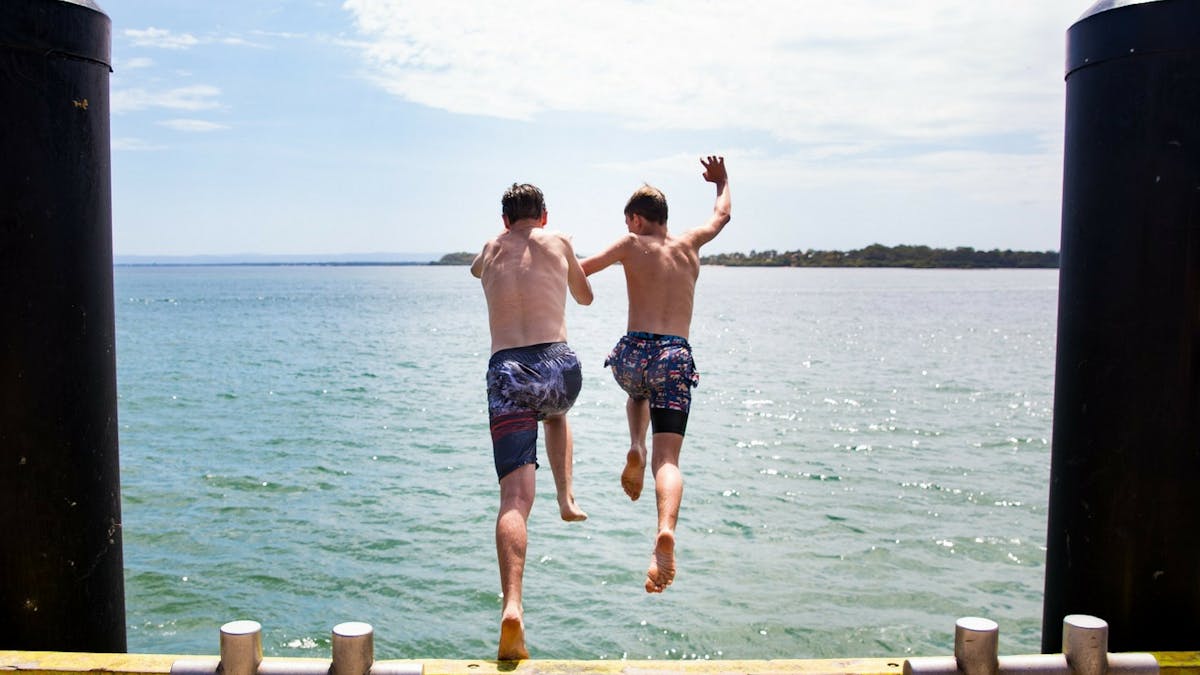 Boys jumping into the water at Bribie Island Boys jumping into the water at Bribie Island