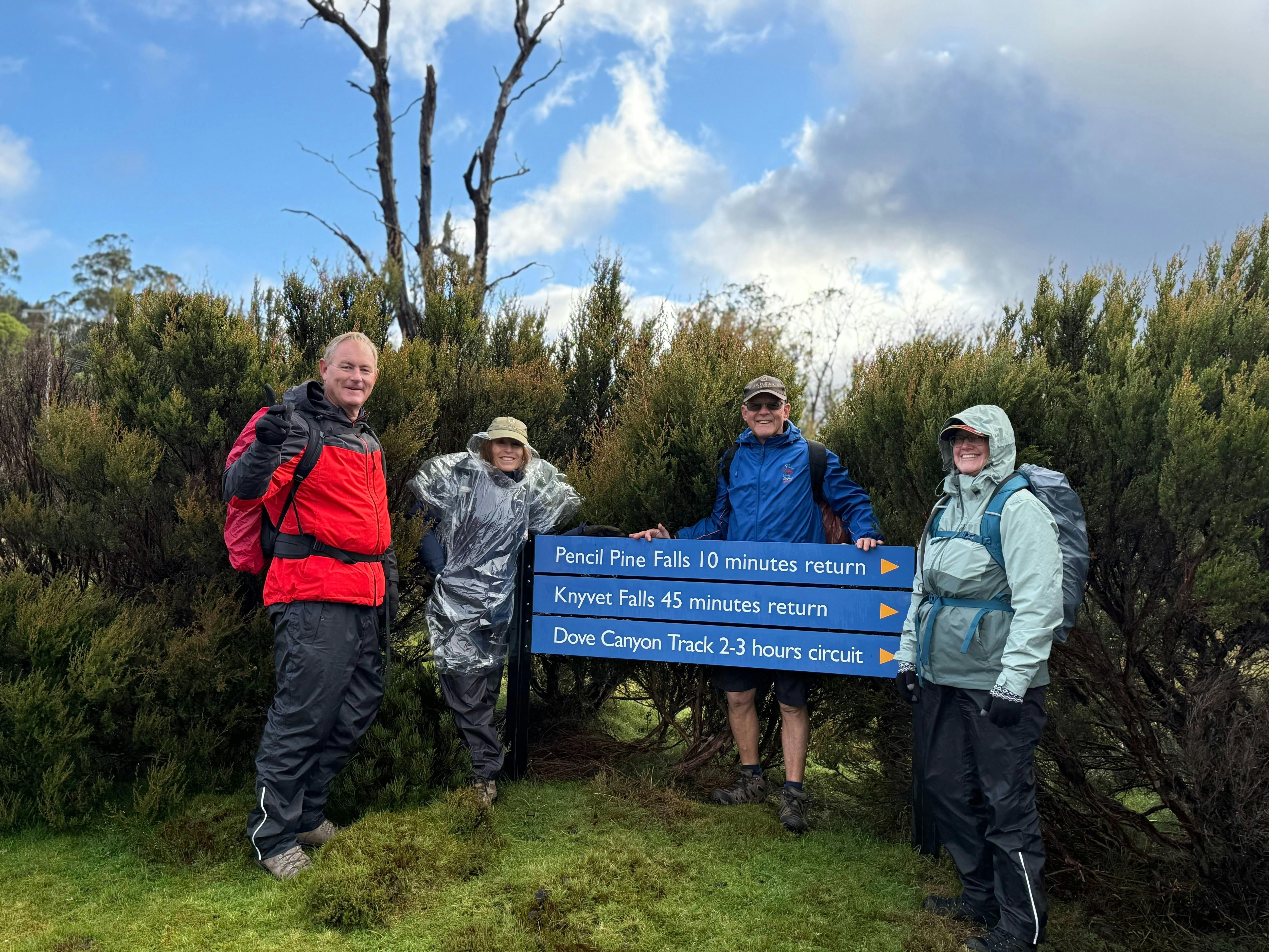 Group of hikers standing at walking track sign in Walls of Jerusalem National Park Tasmania.