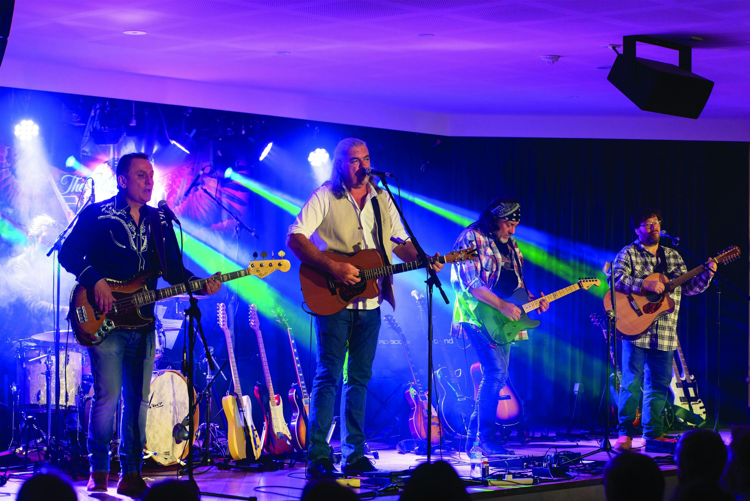An image of 3 guitar players on stage