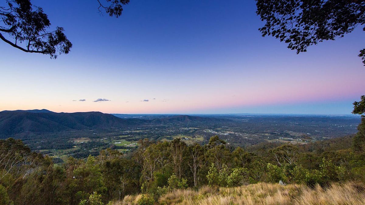 Purple and pink sunset across valley and hinterland landscape