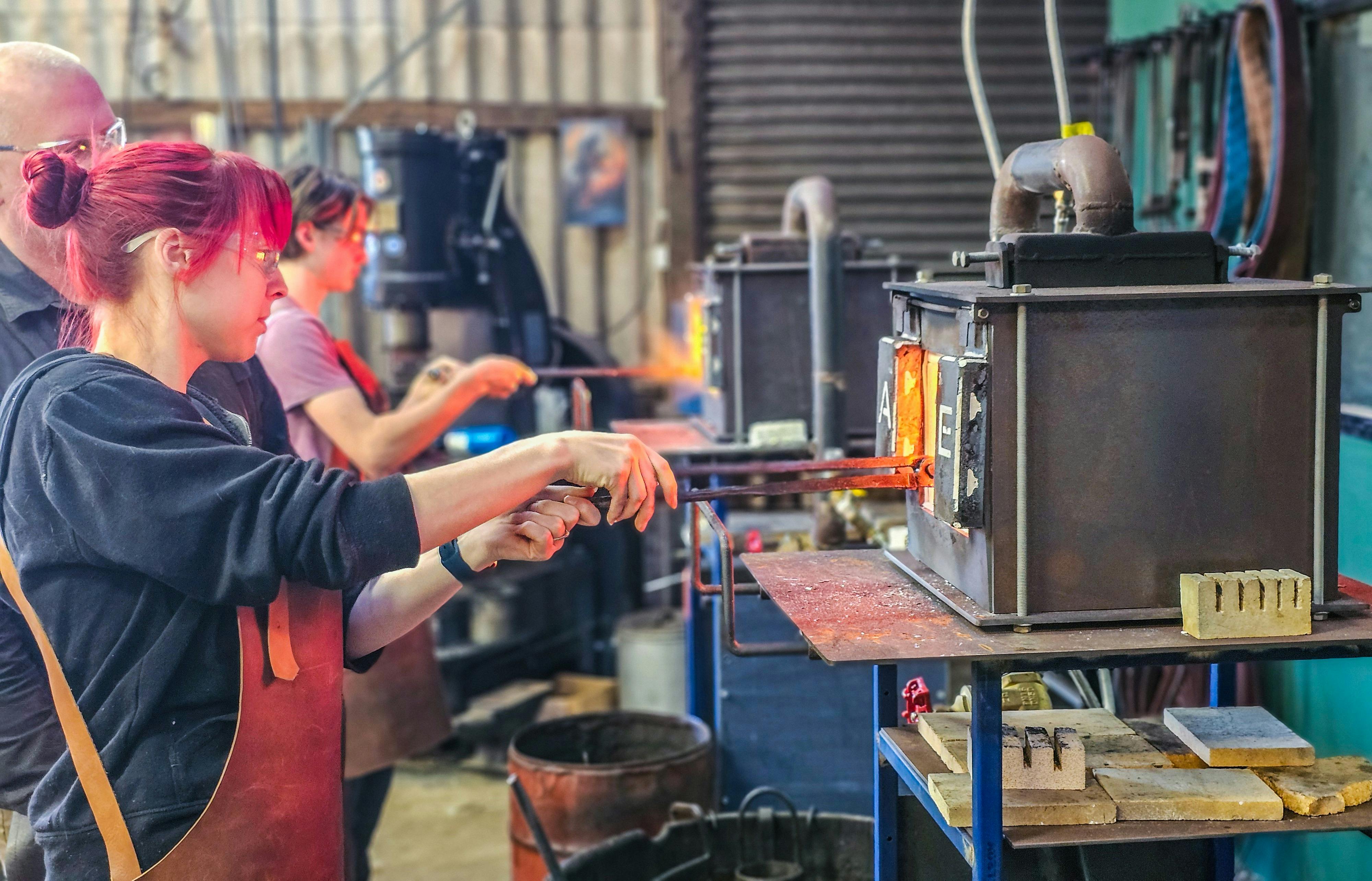 Young woman at a blacksmithing forge