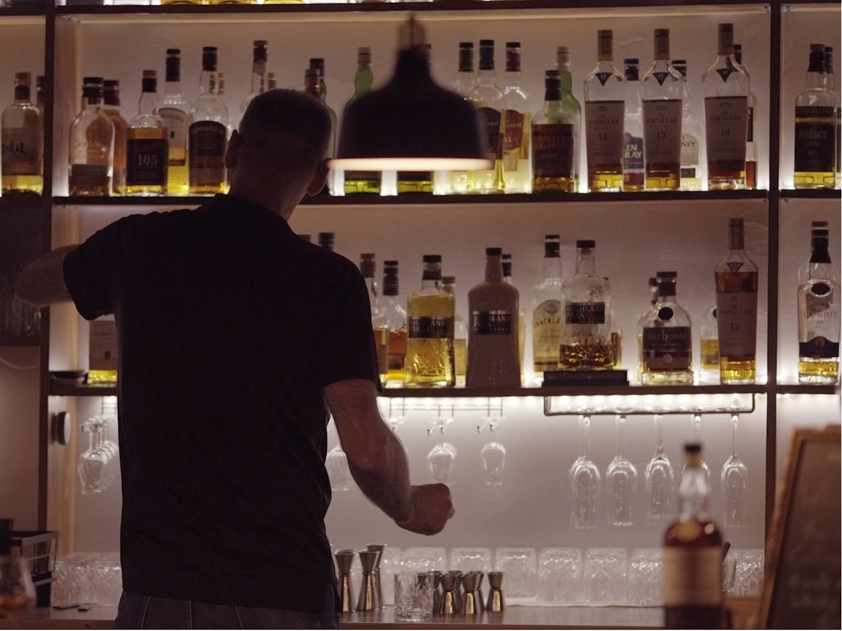 Uwe owner of whisky lounge pouring drinks at the bar Uwe owner of whisky lounge pouring drinks at the bar