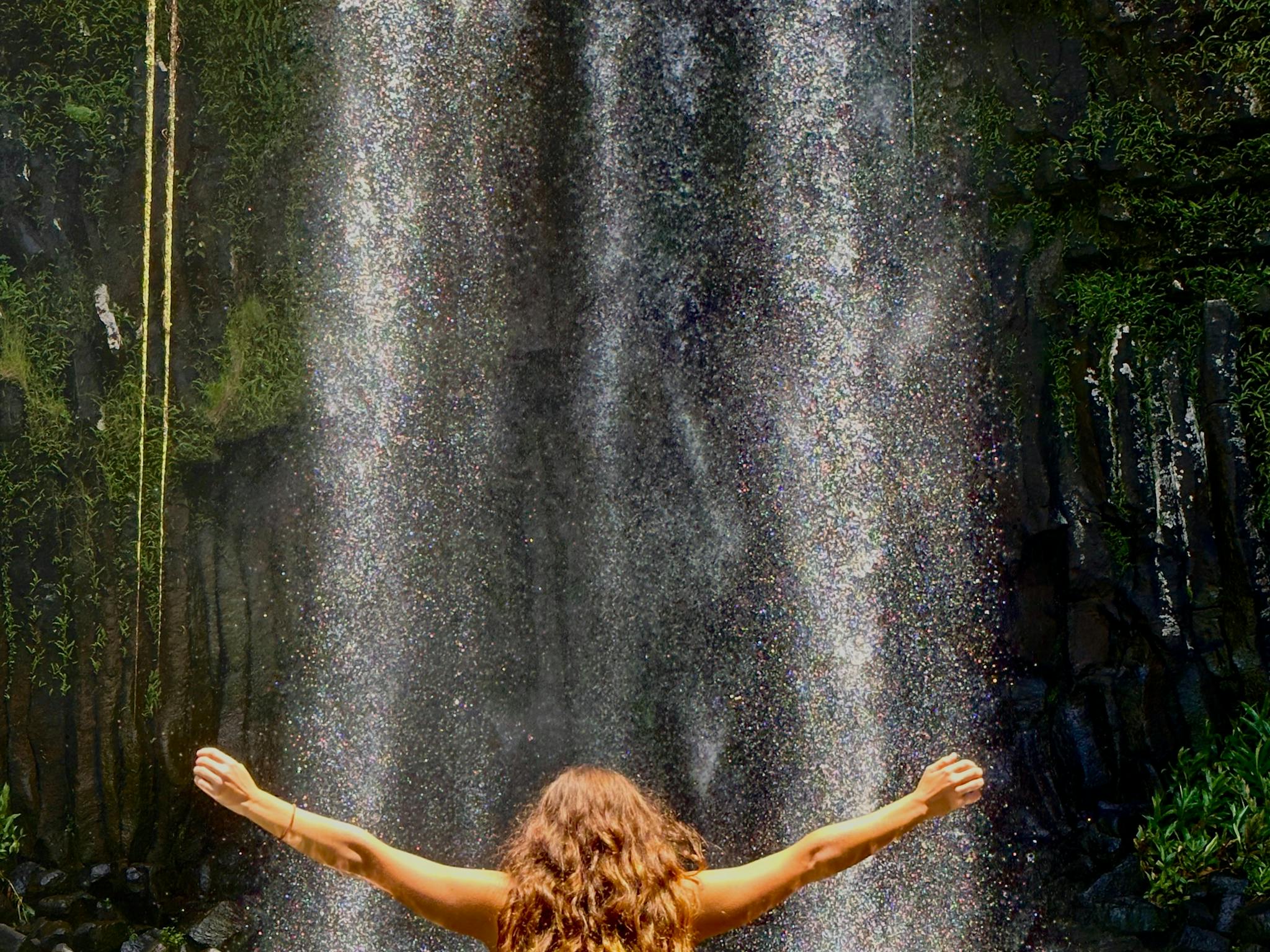 Woman standing in the water in front of Millaa Millaa Falls on the Atherton Tablelands Woman standing in the water in front of Millaa Millaa Falls on the Atherton Tablelands