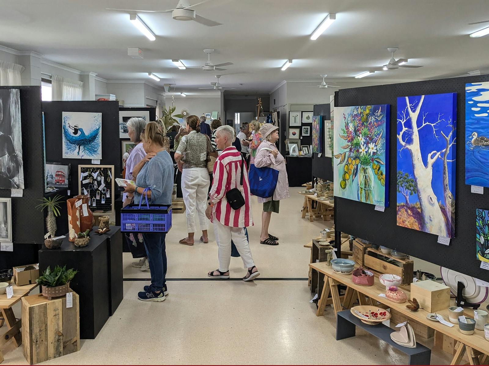 Visitors looking at stunning pottery and Fine Art at Caloundra Arts Centre's Artisan Fair