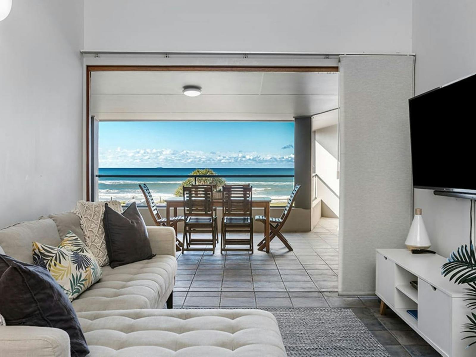 living room overlooking outdoor patio with ocean views