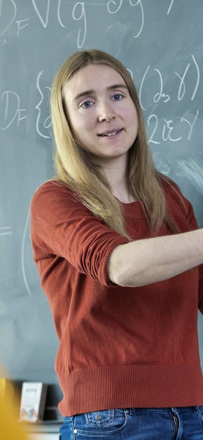 Dr Sol H Jacobsen illustrates physics using diagrams on a blackboard