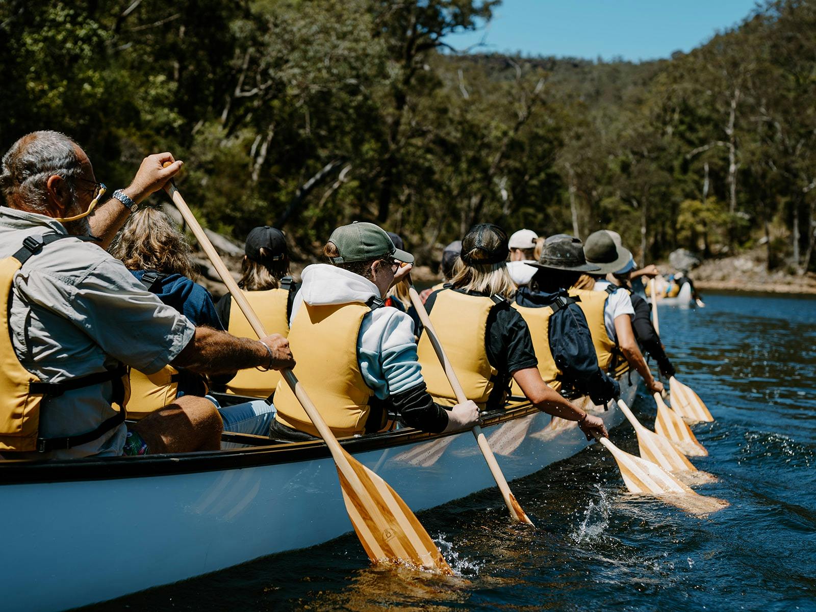 A group in a BIG canoe paddling away
