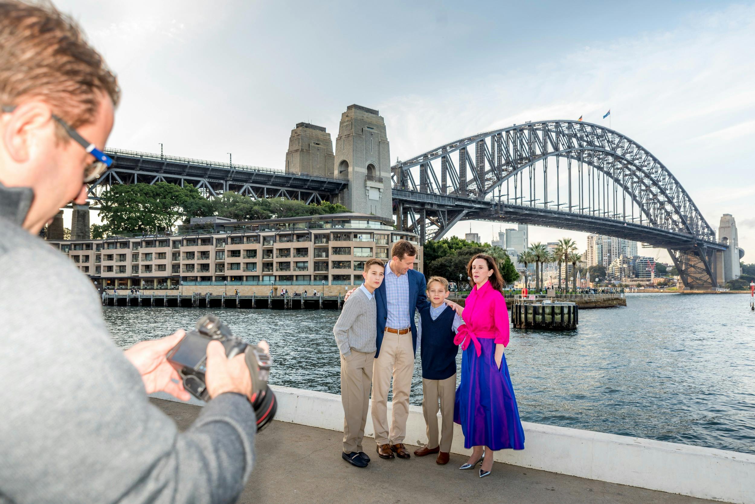 Photography checking his camera with family near Sydney Harbour Bridge