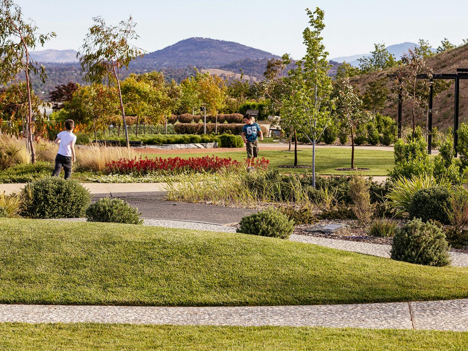 landscape image of the green gardens with two kids running