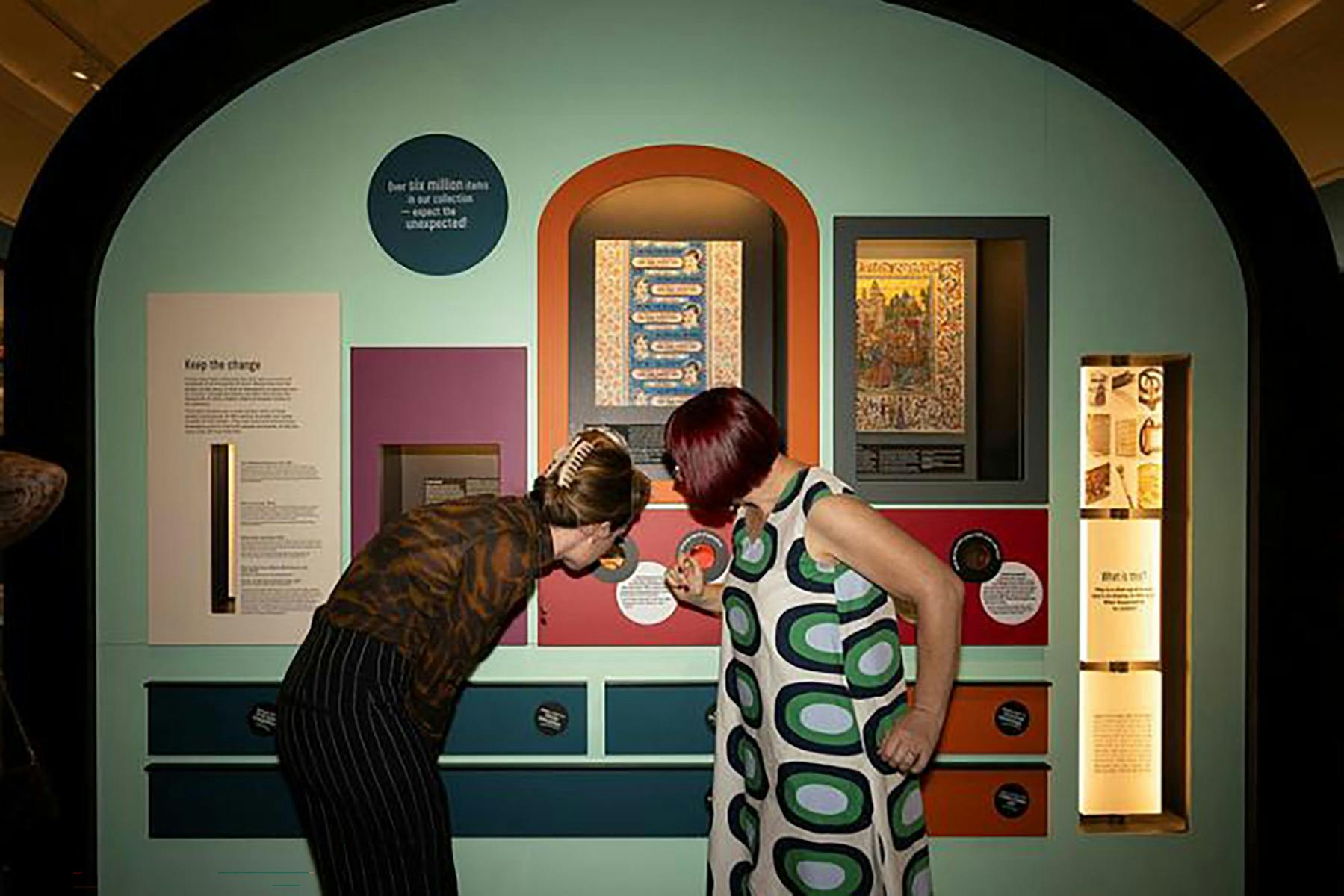 Two women looking at an exhibition wall