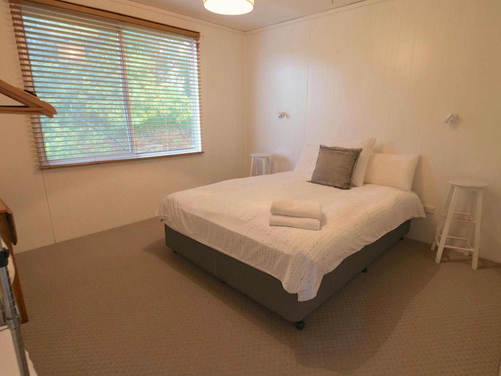 Queen size bedroom with duck feather doona and wool blankets.