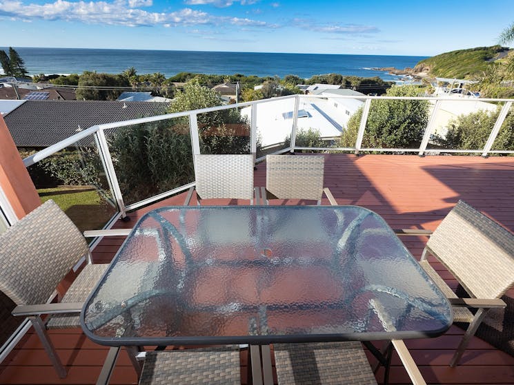 Outdoor deck area with 6 seater dining setting and panoramic ocean views