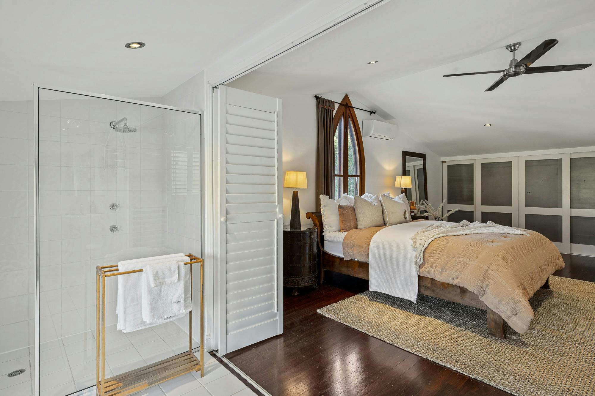 Elegant bedroom with a king-sized bed, soft linens, bedside tables, and natural light.