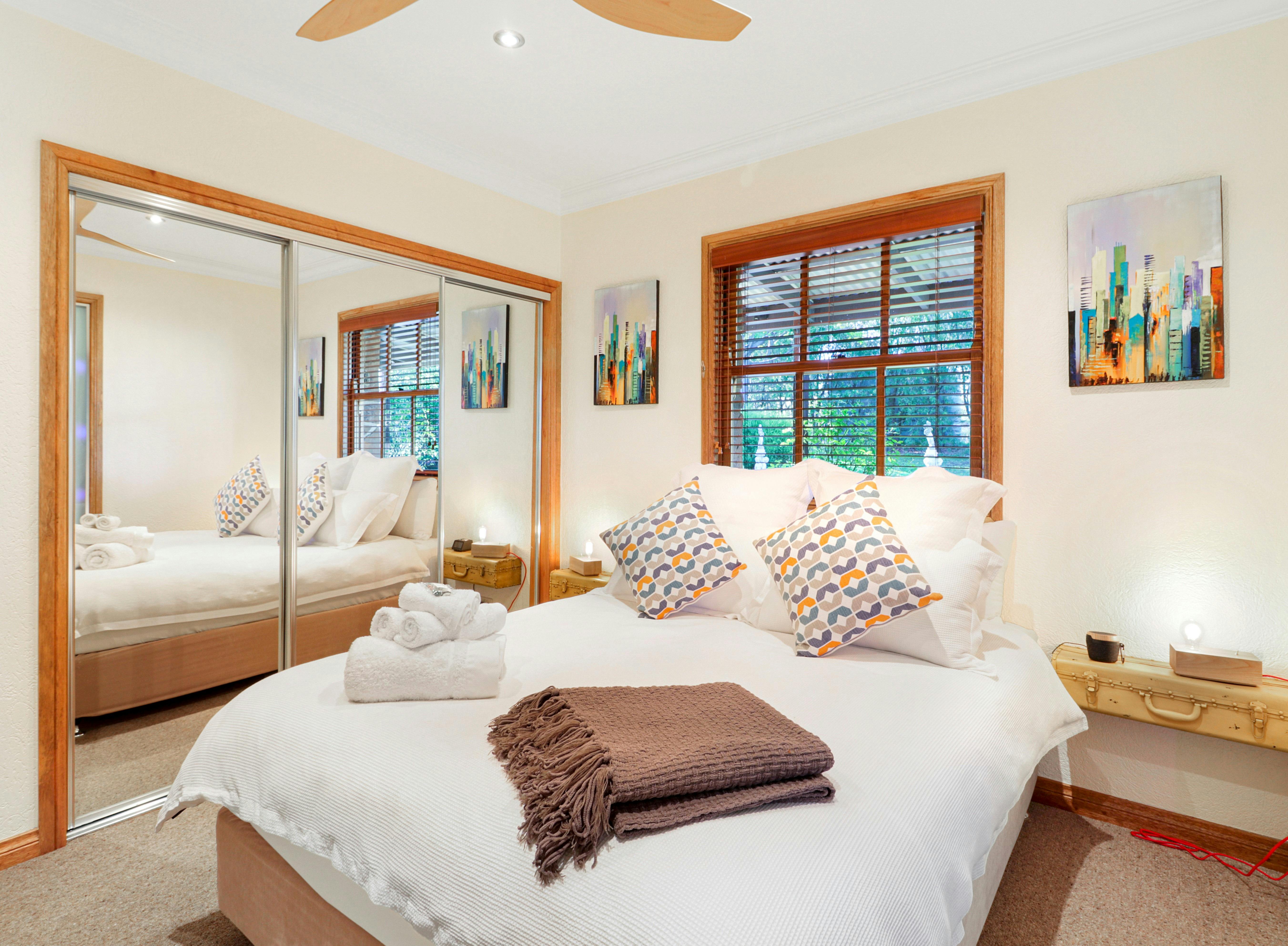 Second bedroom at Stone Creek Cottage  with ceiling fan and querky lights and bedside tables