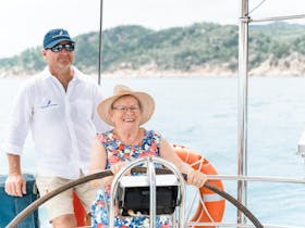 Skipper showing a lady how to drive the boat