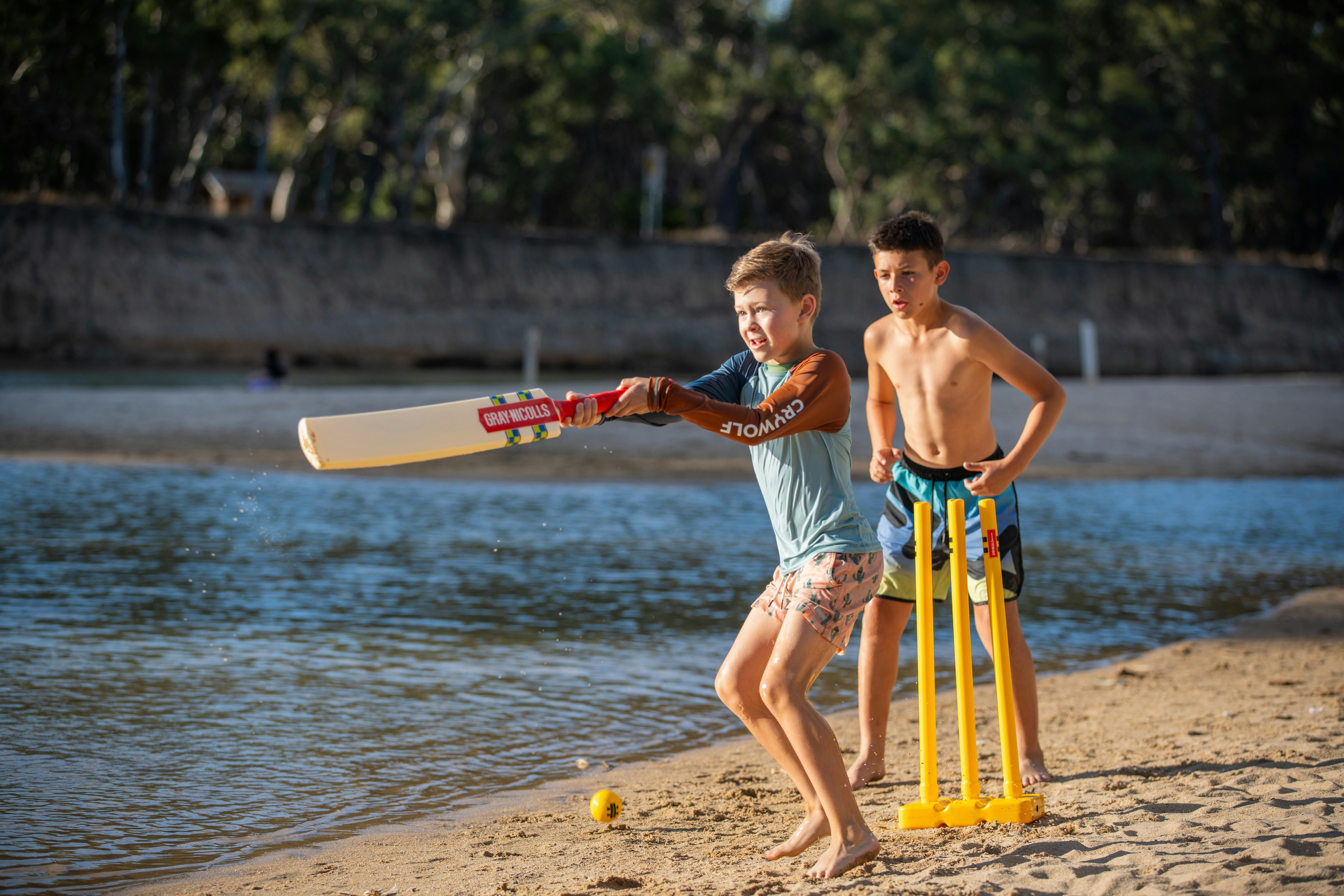 Kids play cricket on the banks of the Edward River