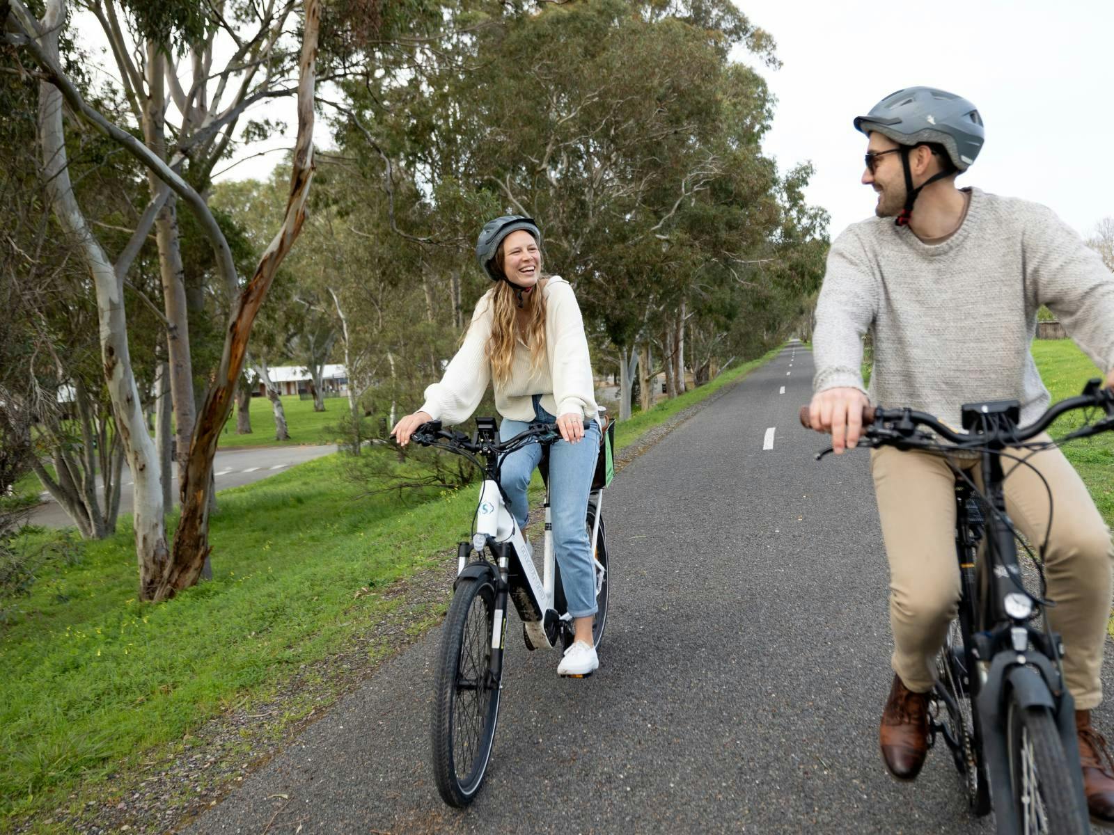 A man and a woman riding along the Shiraz Trail in McLaren Vale