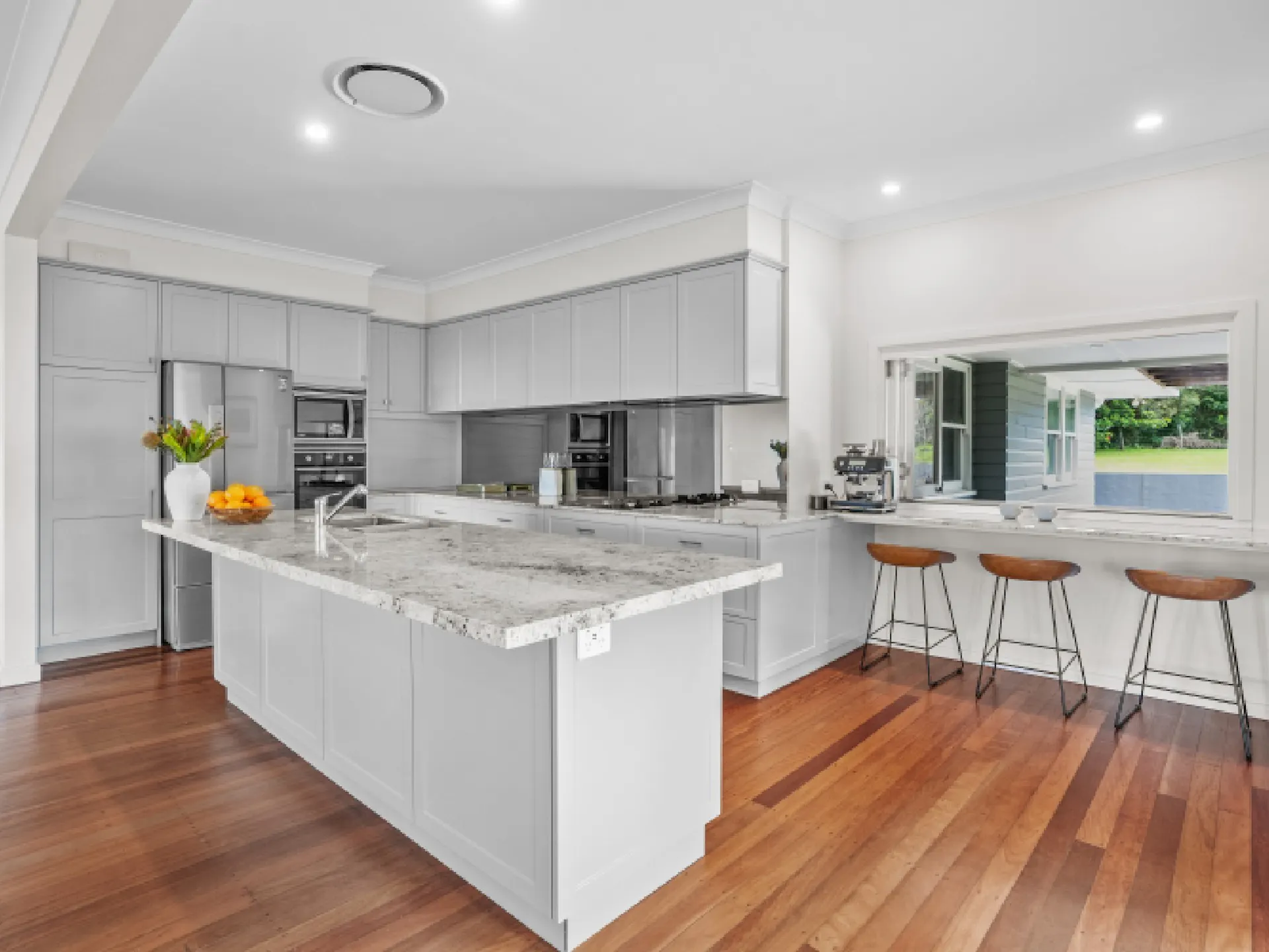 Fully equipped kitchen with breakfast bar that has sliding windows opening onto the front balcony