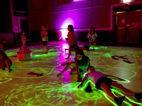 Children play with UV torches on glow in the dark panels