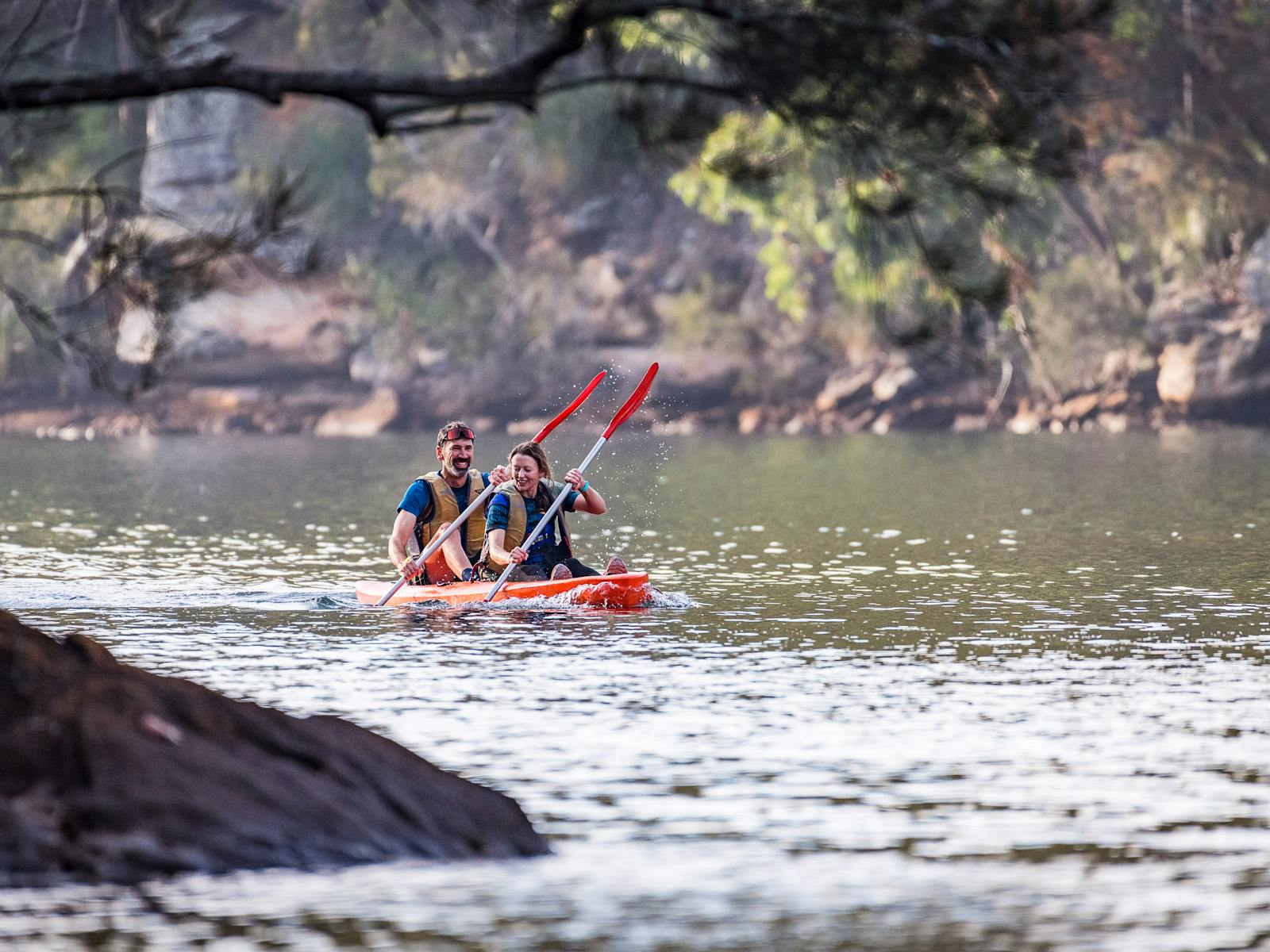 Two kayakers paddle toward the camera