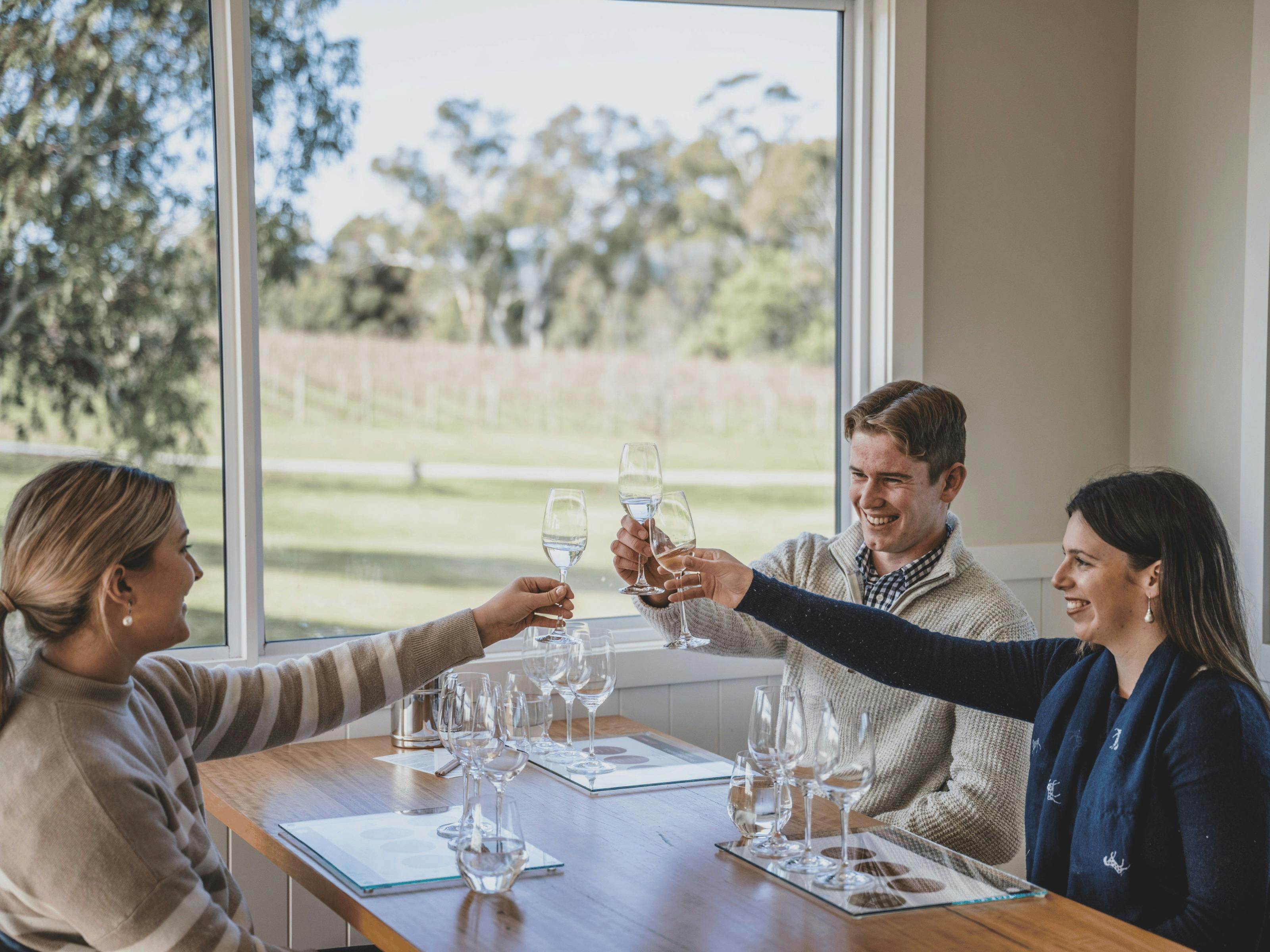 와인 시음회에서 와인잔을 들고 환호하는 3명