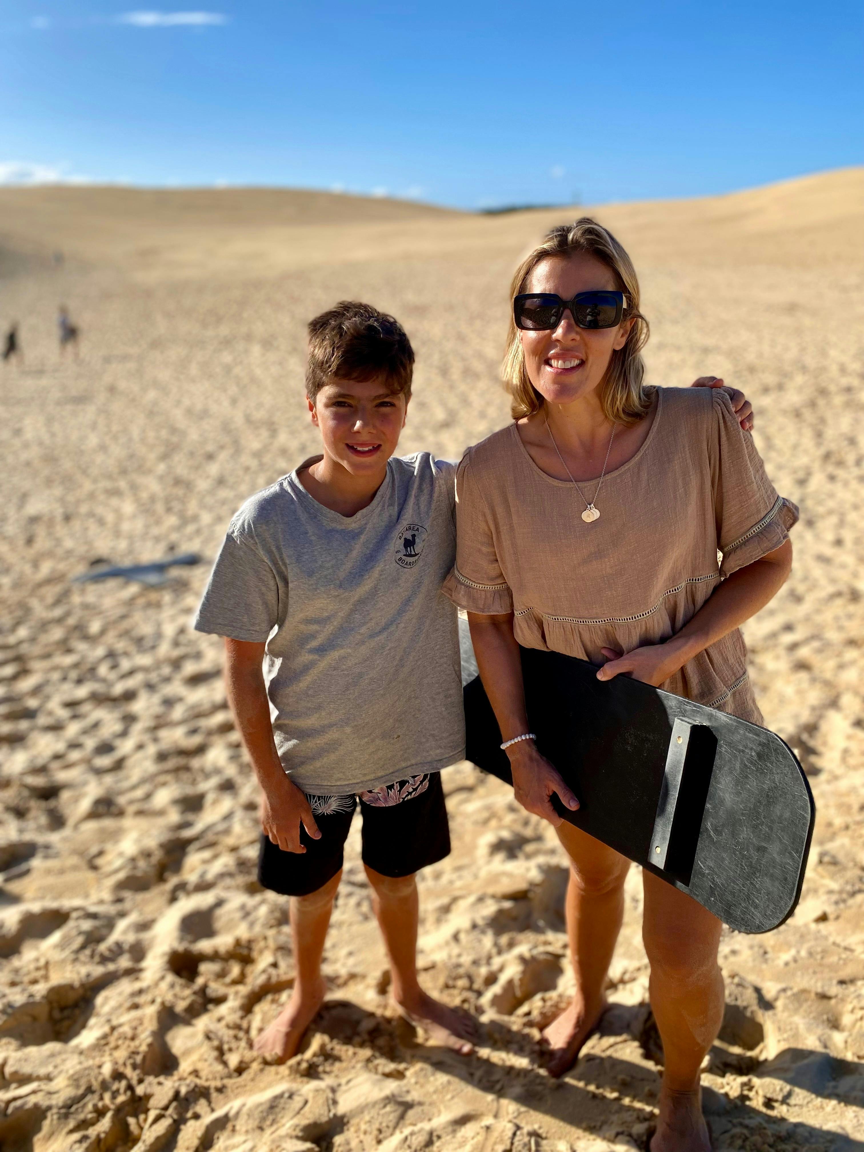 mother and son posing after sliding down the sand dune.