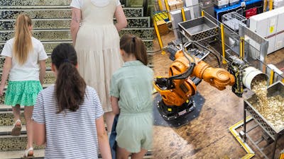 Three children with a guide and titan the robot pouring coins