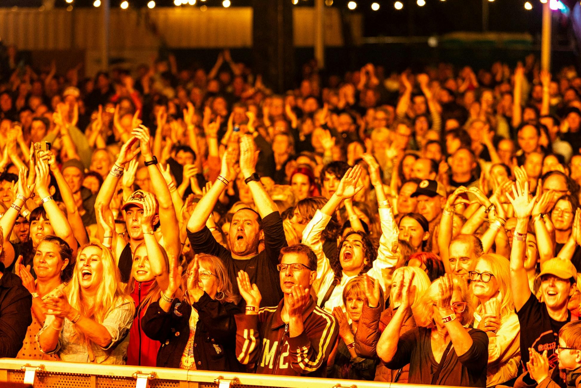 Crowd cheering in the glow of the stage