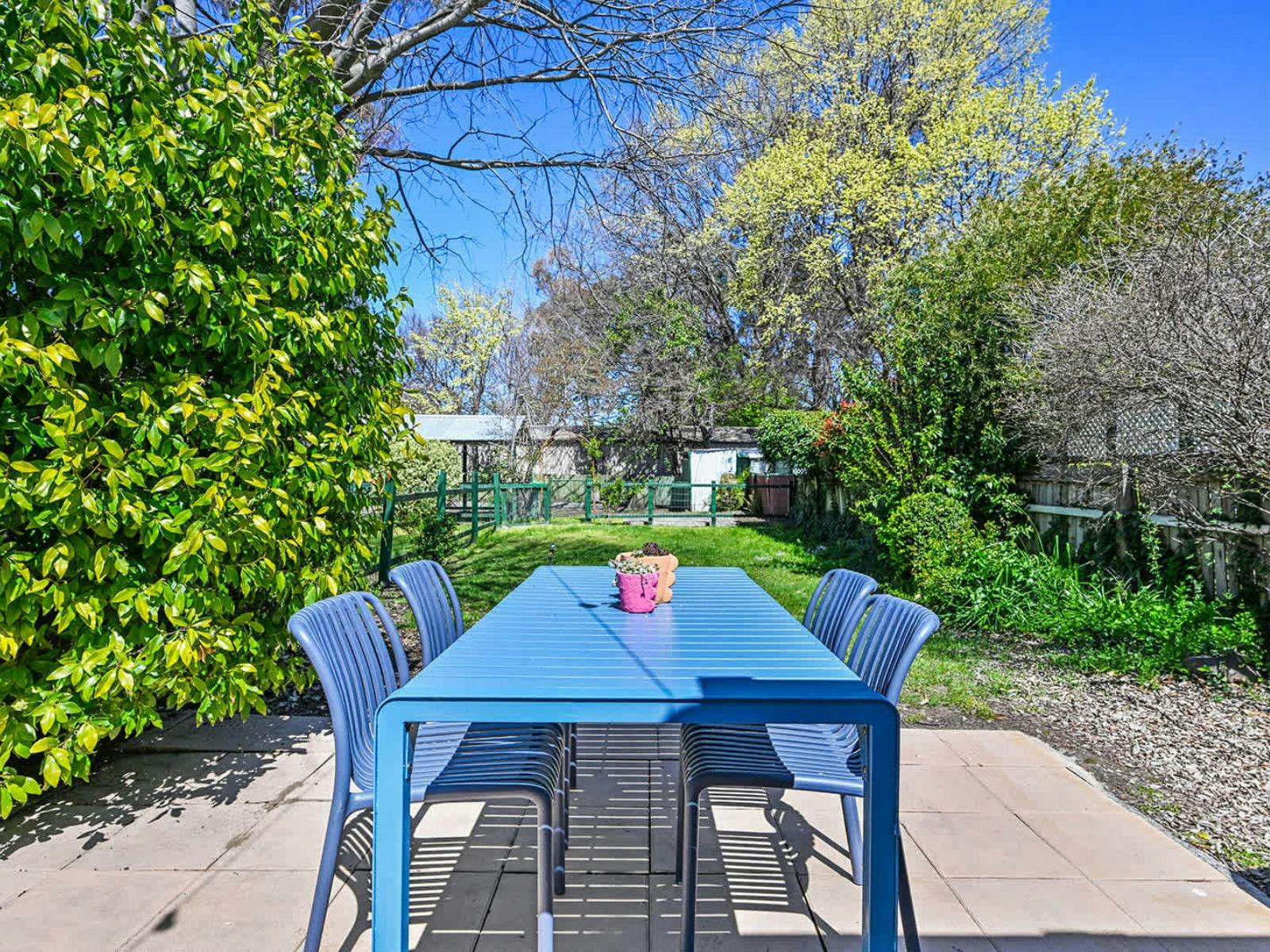 Blue dining table and chairs in the large backyard