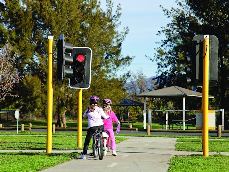 Girls riding bikes stopped at a red light