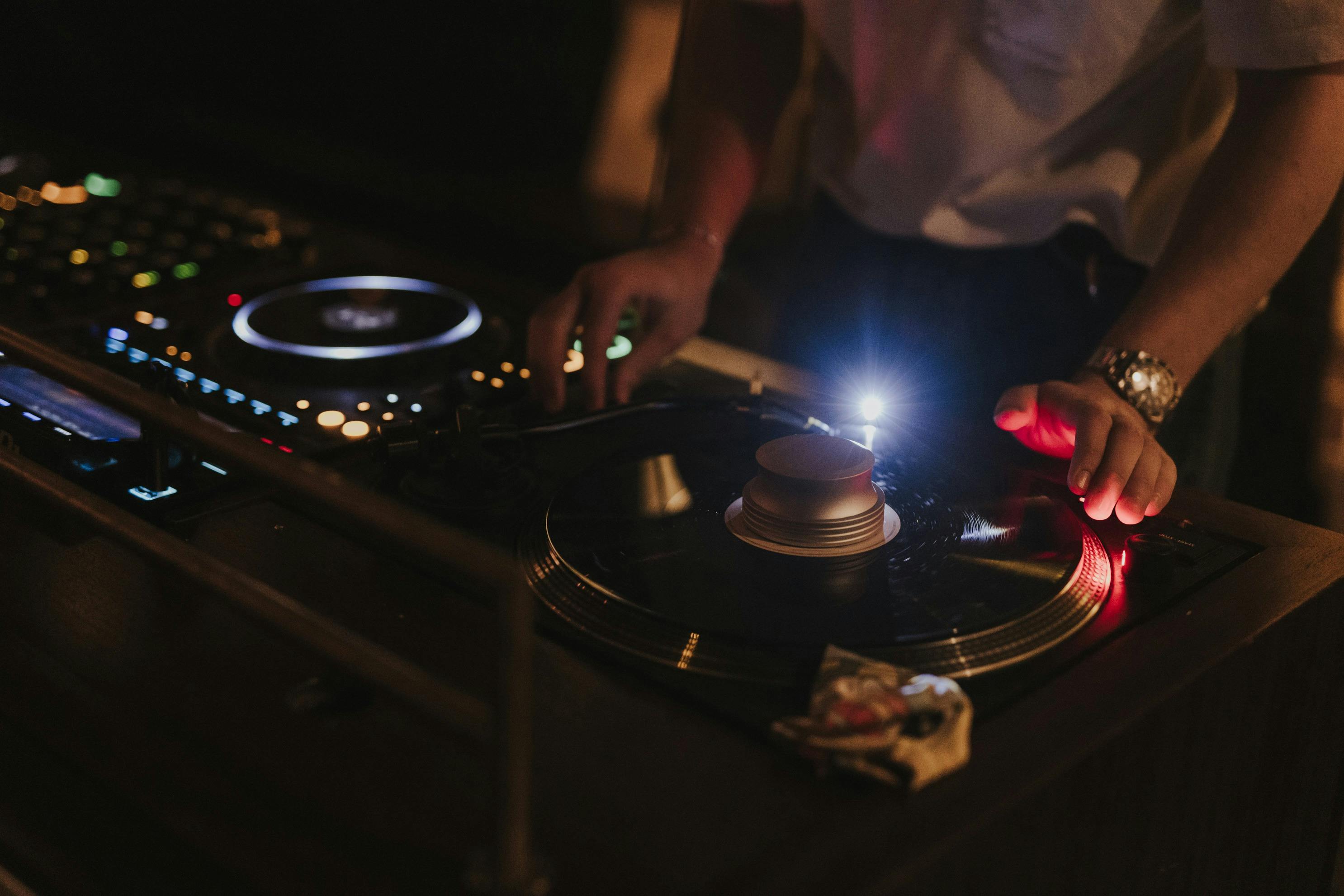 A DJ spins a vinyl record on a turn table