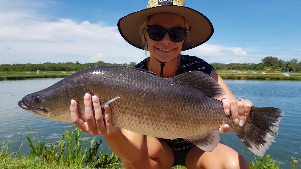 Lady holding up barramundi