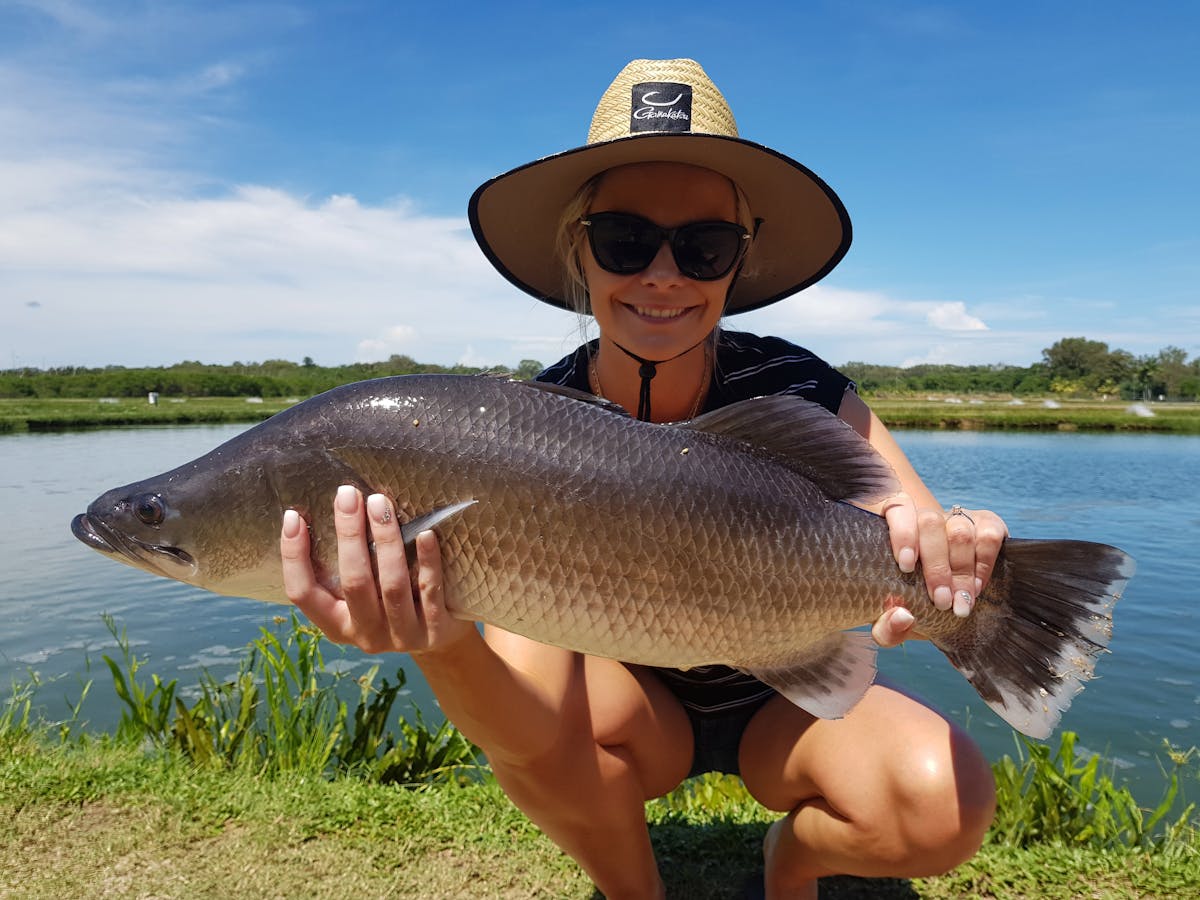 Lady holding up barramundi