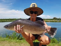 Lady holding up barramundi