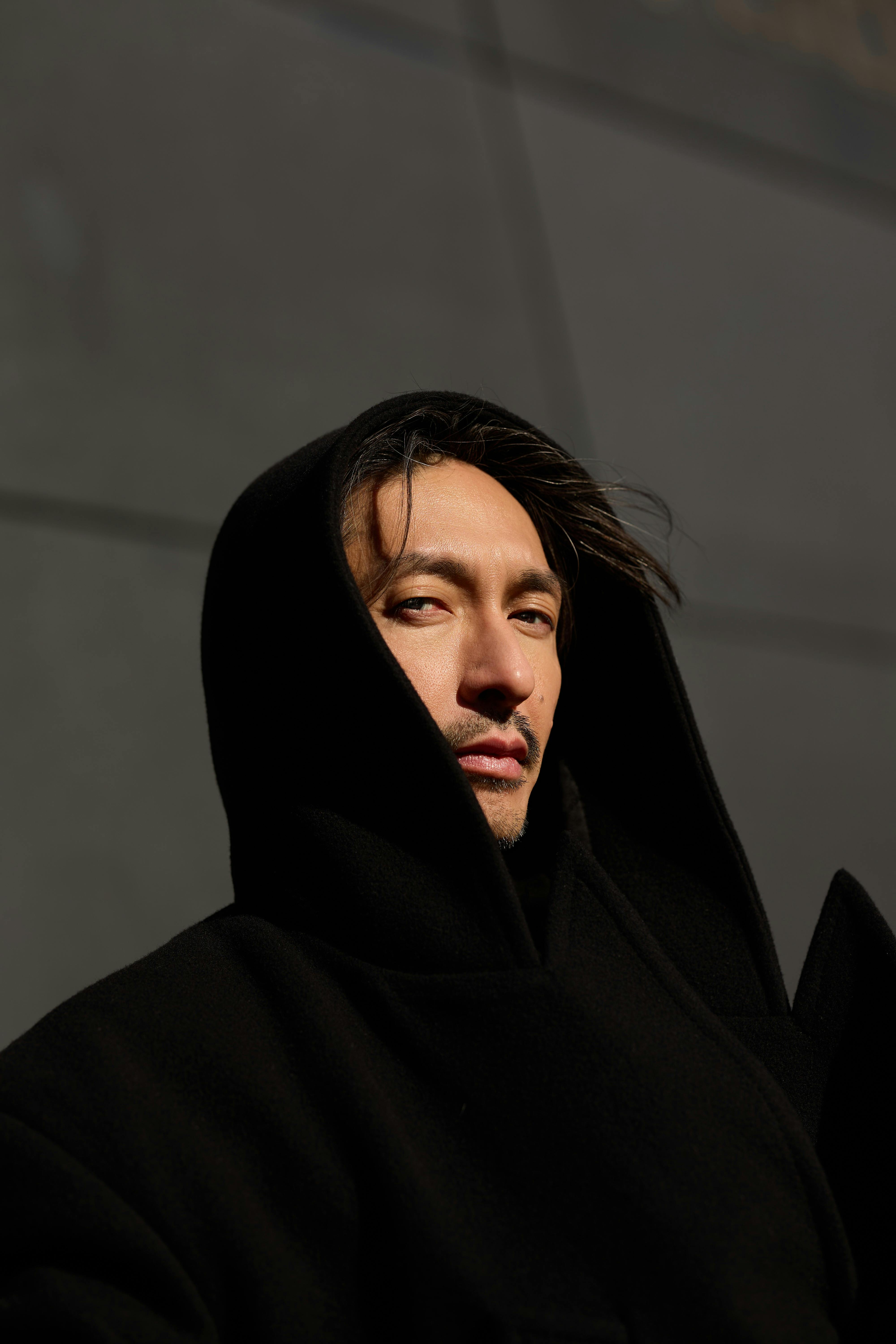 Portrait of a man against a streetscape or building background.