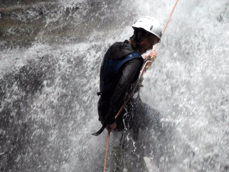 Descending a waterfall by rope into a canyon