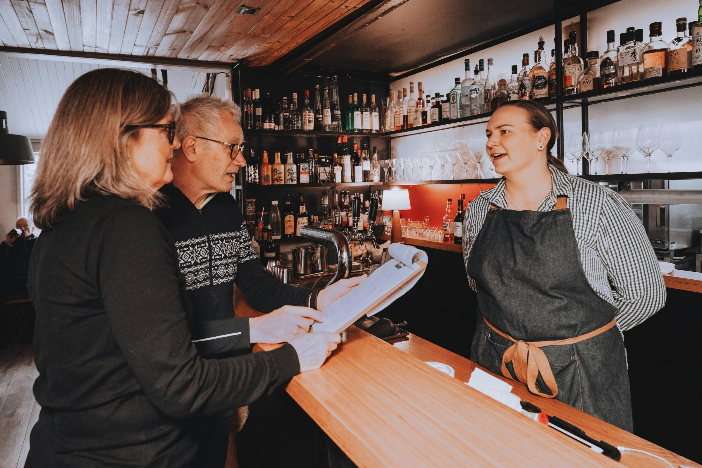 Guests chatting with bartender at Feathertop Lodge’s  bar, known for its cocktails and local wines