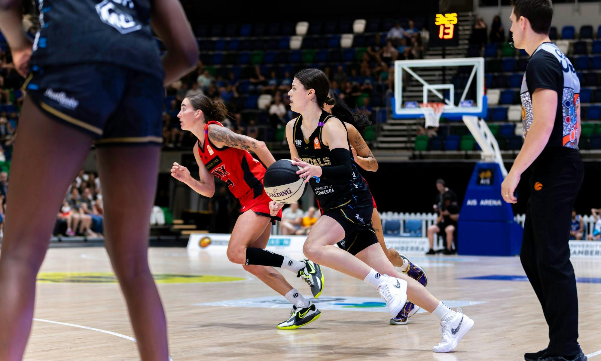 UC Capitals player driving to the basket for a layup during a WNBL game.
